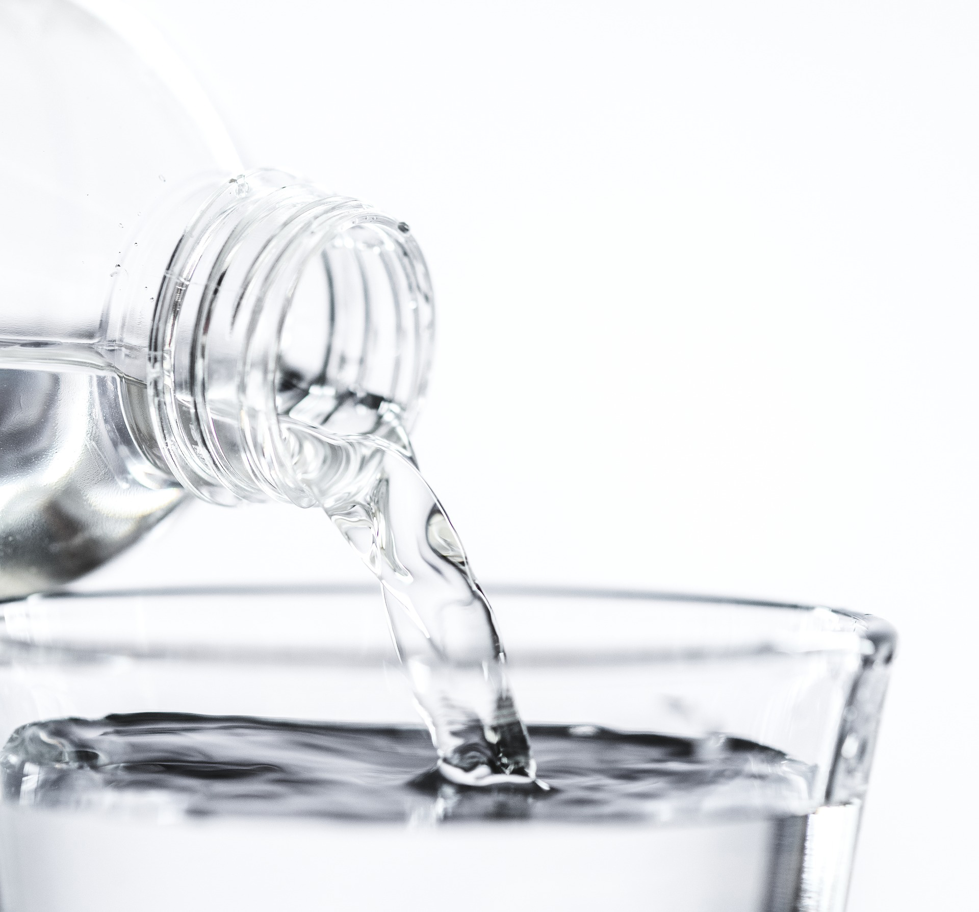 water pouring into a clear glass from a bottle of water