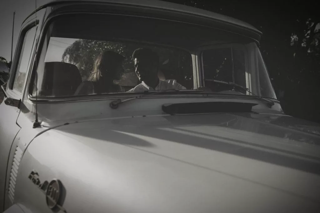 man and woman gazing at each other in the front seat of an old pick up truck