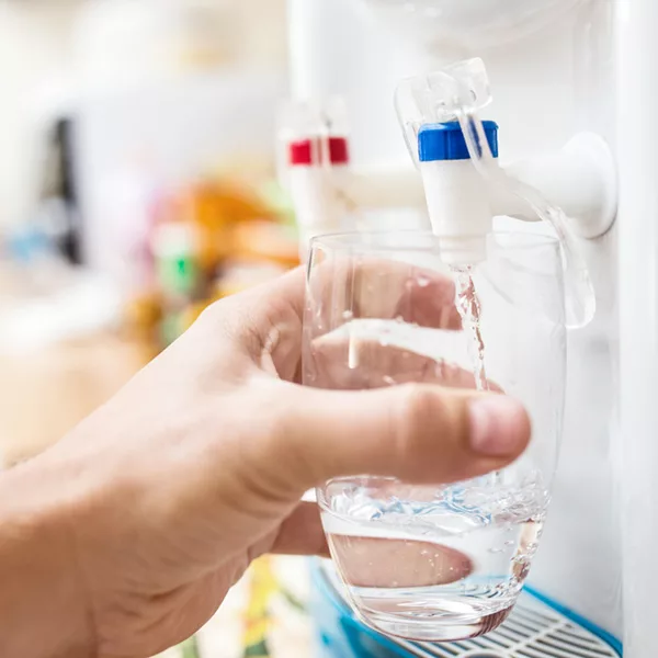 hand holding glass that is being filled from a water dispenser