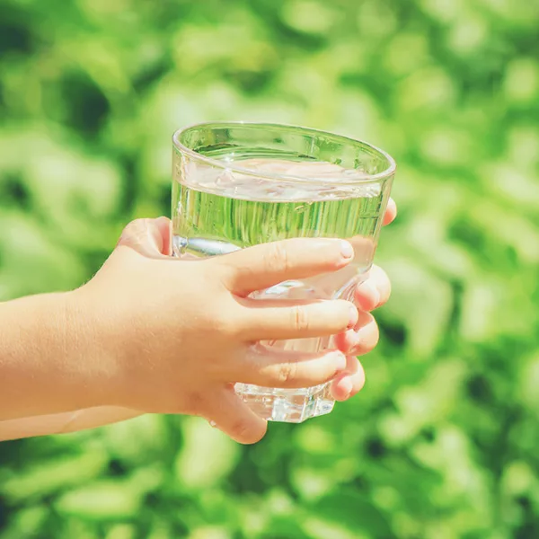 a child holding a full glass of water